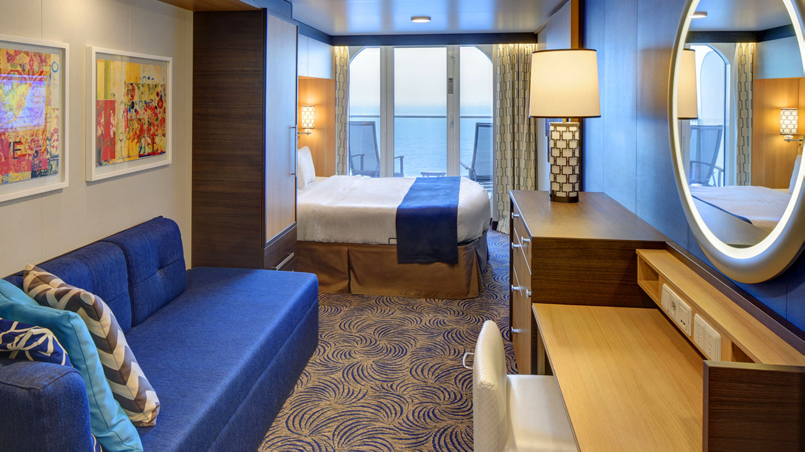 Main view of the Connecting Ocean View Balcony stateroom with vanity, sofa, bed, and balcony.